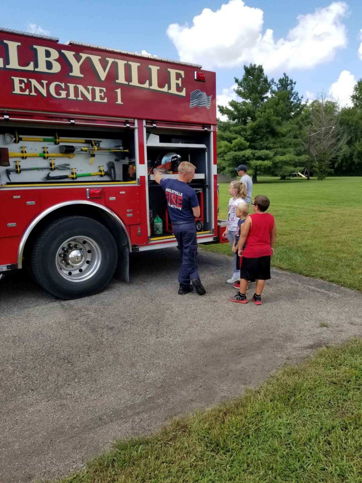 Firefighter showing children fire truck